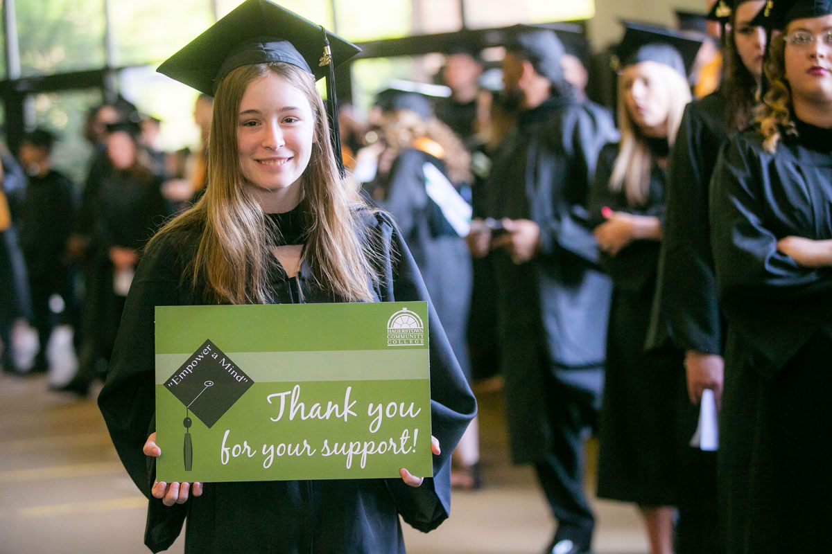 Graduate holding Thank you for your support sign