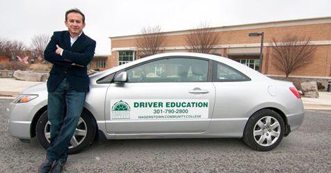 Man leaning against a driver education car