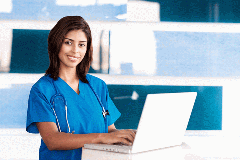 Female medical assistant at a laptop computer looking at the camera